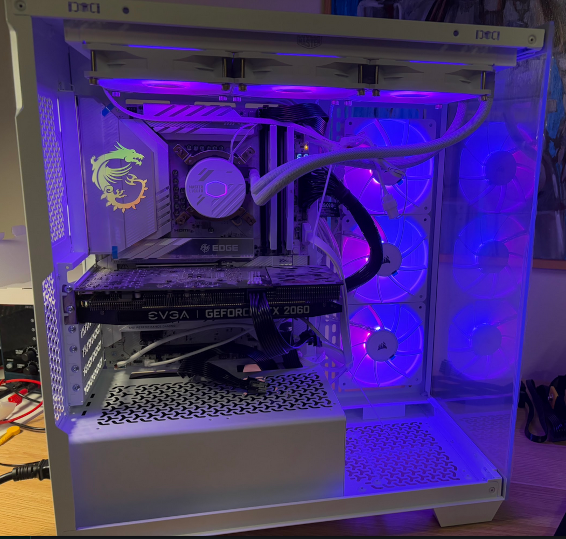 An image of my new copmuter. It's white with blue and red LED's shining ceremoniously throughout. An ancient 2060 RTX graphics card sits awkwardly amidst otherwise new hardware.