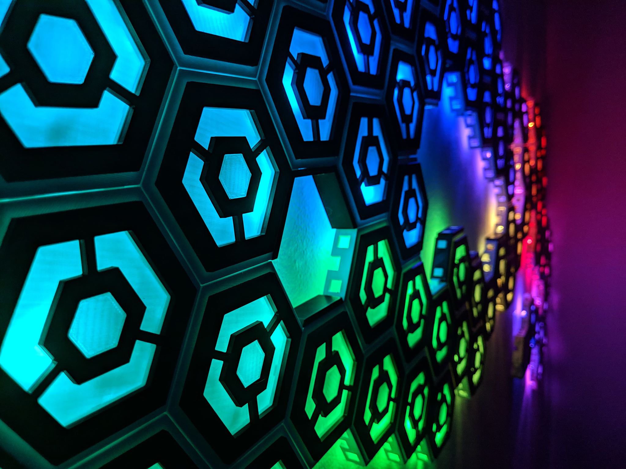 My custom wall art made with multiple ws2812b strands chained together and placed inside custom-built hexagon shells.